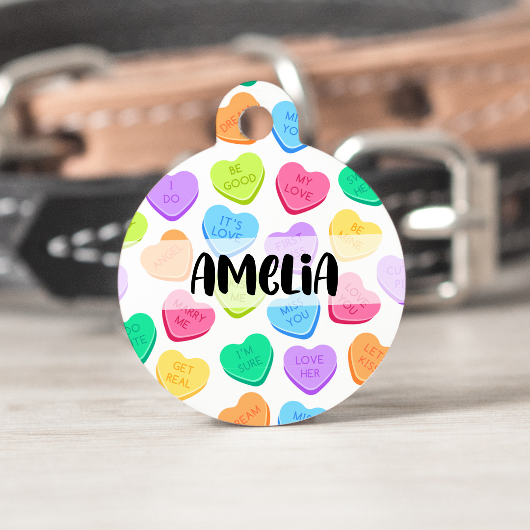 Aluminum pet tag with a white background and candy hearts. Personalized with your pet's name and the back has up to three lines for contact information.