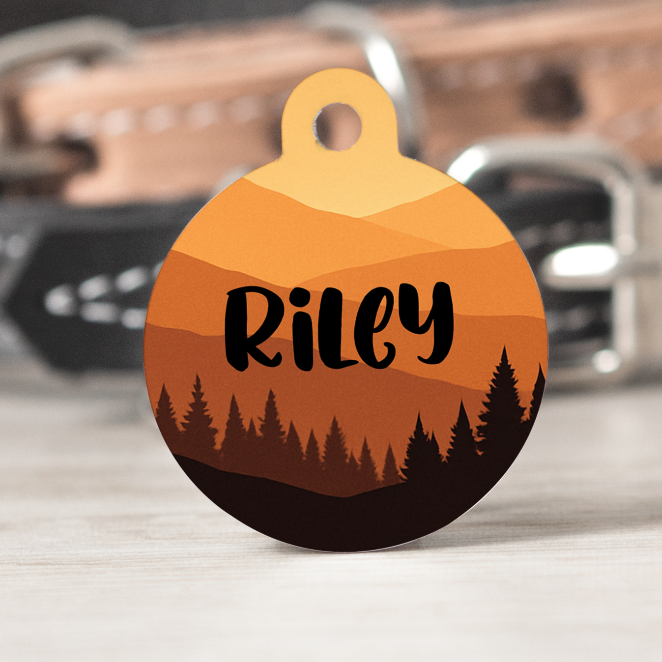 Dog collar with a personalized pet tag featuring a forest design and the name 'Riley'.